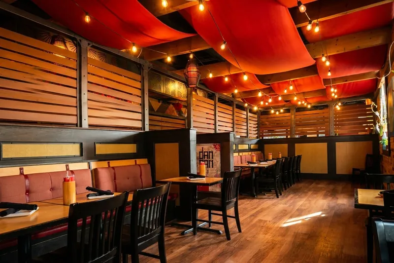 Dining room at DanDan in Milwaukee's Historic Third Ward, with wooden booths, red draped ceiling and a DanDan menu card on the table