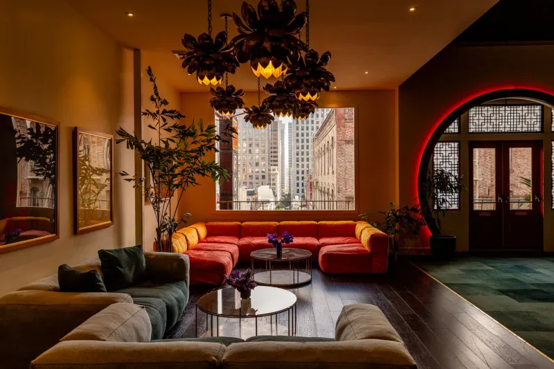 The lounge at Mister Jiu's in San Francisco's Chinatown, with a red neon-lit moon gate entrance