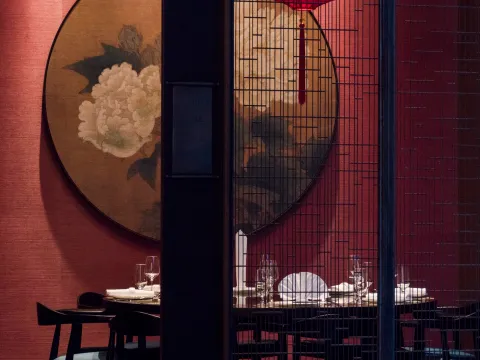 Dining room with red walls, a peony painting and lattice screens at Meizhou Dongpo, Century City