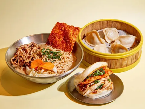 Three Fold spread in Little Rock — a bowl of braised-pork noodle soup with a crispy chili cracker, a bamboo steamer of dumplings, and a steamed bun filled with fried chicken and pulled pork